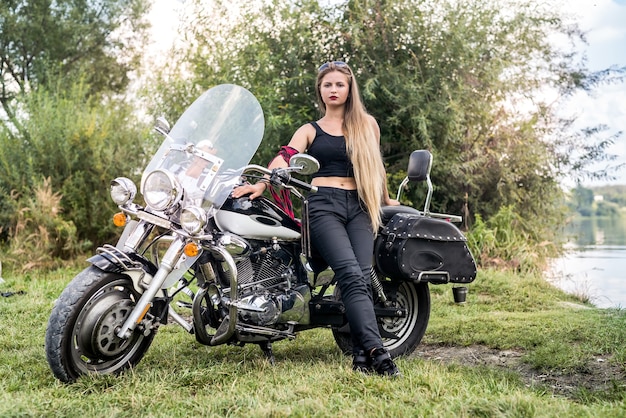 Eine schöne blonde Frau sitzt auf einem Motorrad