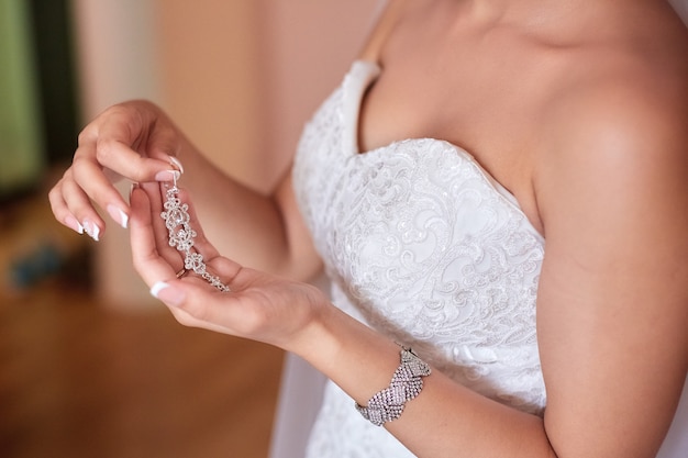 Eine schöne Braut in einem langen Kleid im Hotel und warten auf den Bräutigam. Juwelen der Braut