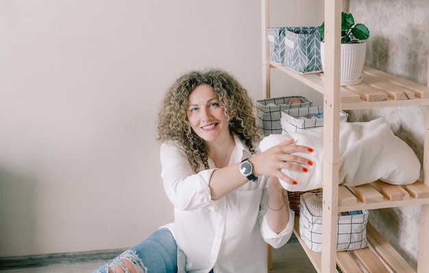 Eine schöne Frau bringt Ordnung in den Kleiderschrank, ordnet die Dinge an ihren Platz. Ordnung und Komfort im Haus