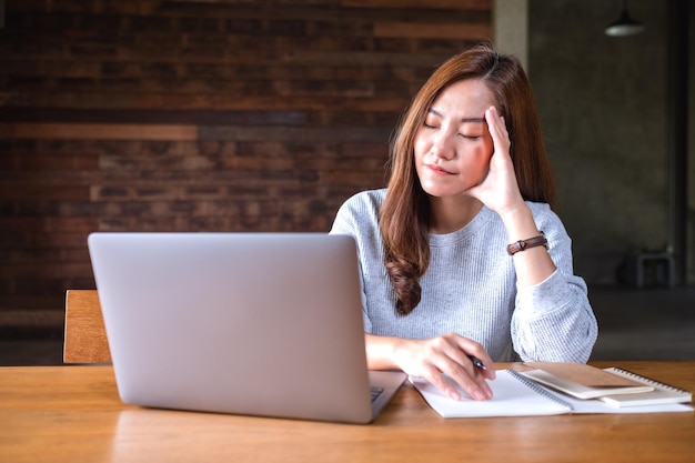 Eine schöne junge Asiatin wird beim Arbeiten am Laptop gestresst
