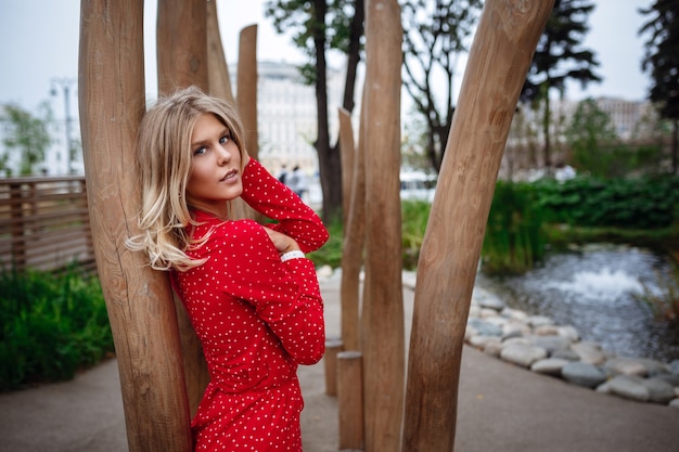 Eine schöne junge blonde Frau in einem hübschen kurzen roten Kleid geht im Zentrum von Moskau spazieren. Die zentralen Orte der Stadt.