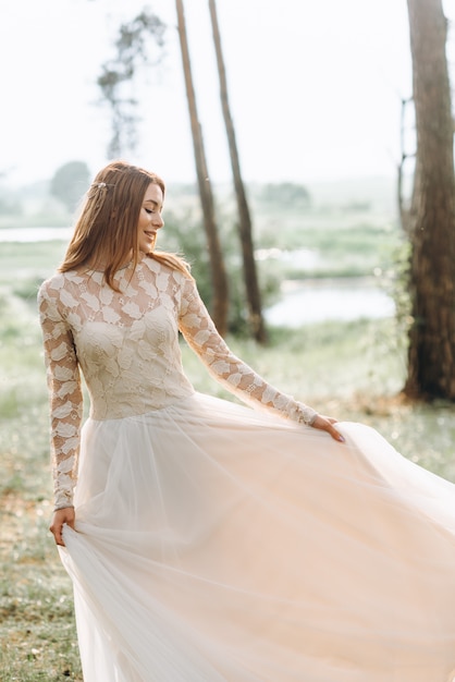 Eine schöne junge Braut im weißen Kleid in einem Wald