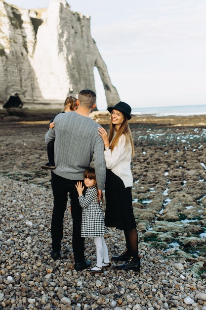 Foto eine schöne junge familie am sandigen ufer des ozeans, die sich entspannt und spaß hat