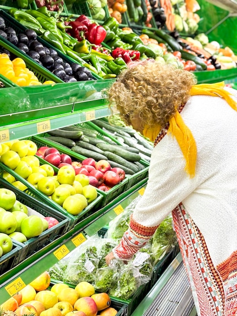 Eine schöne junge Frau kauft Obst und Gemüse in der Lebensmittelabteilung eines Lebensmittelgeschäfts, einem Supermarkt.