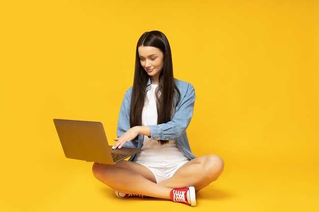 Eine schöne junge Frau mit einem Laptop in den Händen