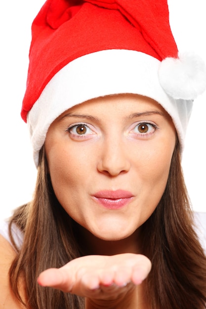 Foto eine schöne junge frau mit weihnachtsmütze schickt küsse auf weißem hintergrund