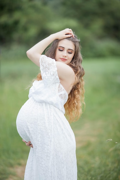 Eine schöne junge schwangere Frau posiert