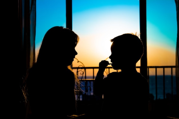 Eine schöne Silhouette von glücklichen Kindern auf dem Meereshintergrund