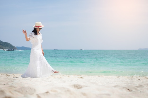 eine schöne sorglose Frau, die am Strand genießt ihre Sonnenkleid-Freiheitsabnutzung sich entspannt.