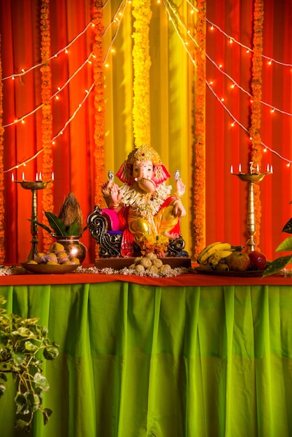 Eine schöne Tonstatue oder ein Idol eines indischen Hindu-Gottes Lord Ganesha, verziert mit bunten Vorhängen und Ringelblumengirlande für Ganesh Chaturthi-Festival oder Pooja