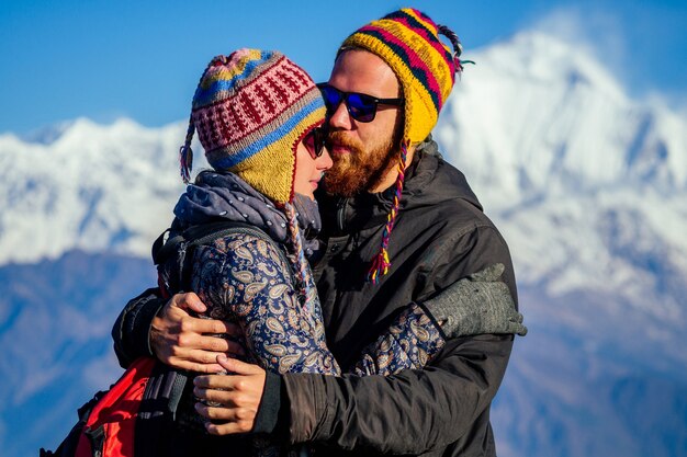 Eine schöne und aktive Frau und ein Mann umarmen sich vor dem Hintergrund der Berge. das Konzept der aktiven Erholung und des Tourismus in den Bergen. Paar in Liebe Trekking in Nepal Himalaya.