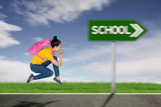Eine Schülerin rennt zur Schule.
