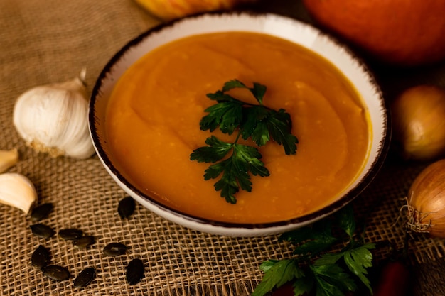 Eine Schüssel Kürbissuppe mit Gemüse auf dem TischRustike Herbstnahrung Diätsuppe