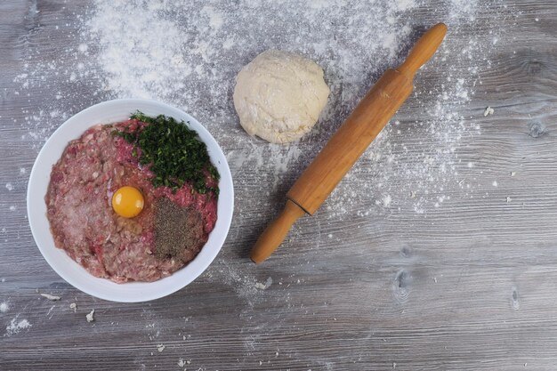 Foto eine schüssel mit essen und daneben ein nudelholz mit der aufschrift „ei“.