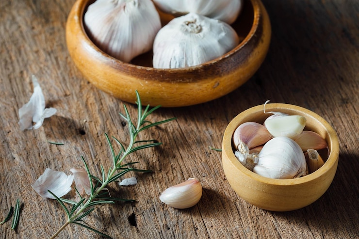 Foto eine schüssel mit knoblauch und knoblauc sitzt auf einem holztisch