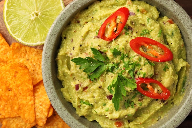 Eine Schüssel mit köstlichen Guacamole-Limetten- und Nachos-Chips lag flach auf dem Tisch