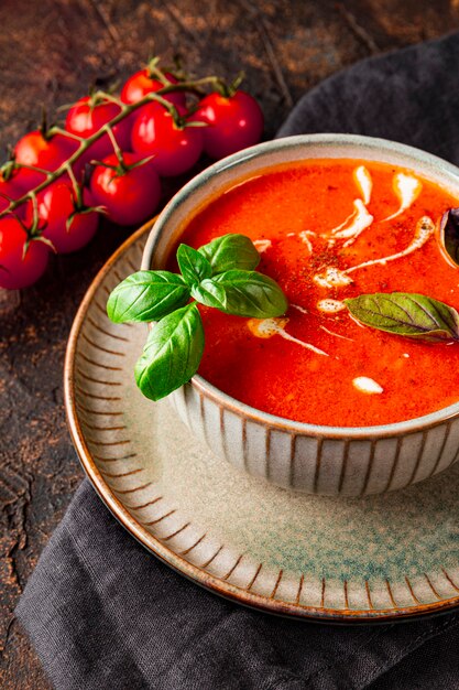 eine Schüssel mit traditioneller spanischer Tomatensuppe mit Sahne und Basilikum auf dem Tisch Nahaufnahme vertikales Foto