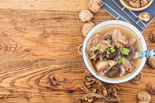 Eine Schüssel Pilz-Lao-Entensuppe auf einem Schneidebrett