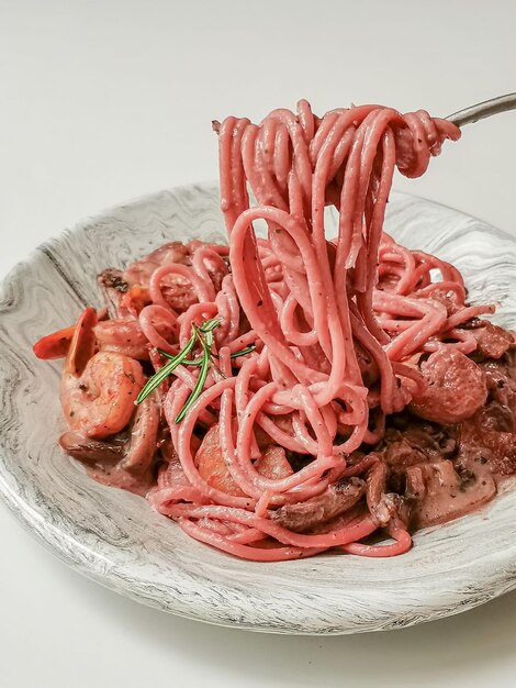 Foto eine schüssel spaghetti mit einer gabel, die eine gabel hineinhebt.