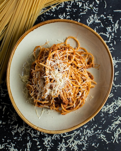 Eine Schüssel Spaghetti mit Spaghetti auf schwarzem Hintergrund.