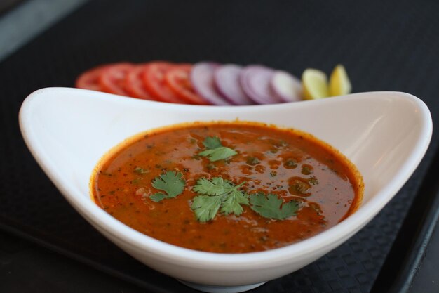 Eine Schüssel Tomatensuppe mit Koriander an der Seite