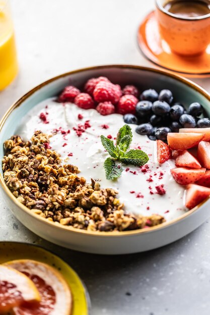 Foto eine schüssel voller beeren, joghurt und getreide gesundes frühstückskonzept