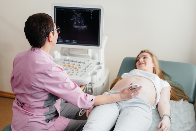 Eine schwangere Frau bekommt in der Klinik einen Ultraschall ihres Bauches. Ärztliche Untersuchung