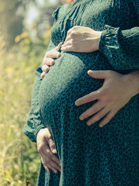 Eine schwangere Frau hält ihre Hände auf ihrem Bauch