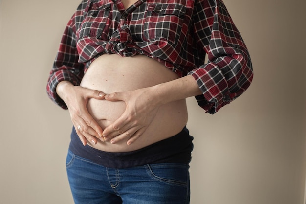 Eine schwangere Frau macht eine herzförmige Hand