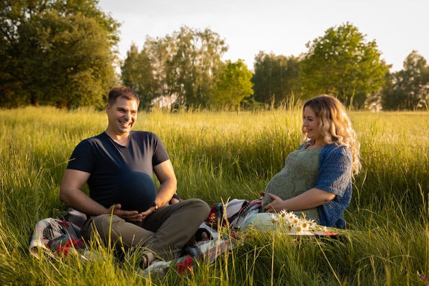 Foto eine schwangere frau mit ihrem ehemann auf einem hintergrund eines feldes