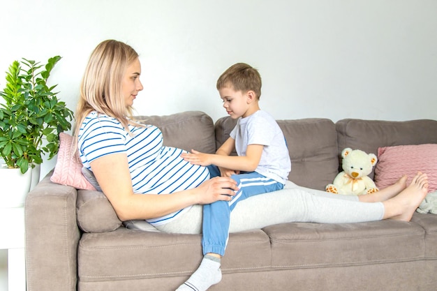 Eine schwangere Frau umarmt ihren ältesten Sohn Selektiven Fokus