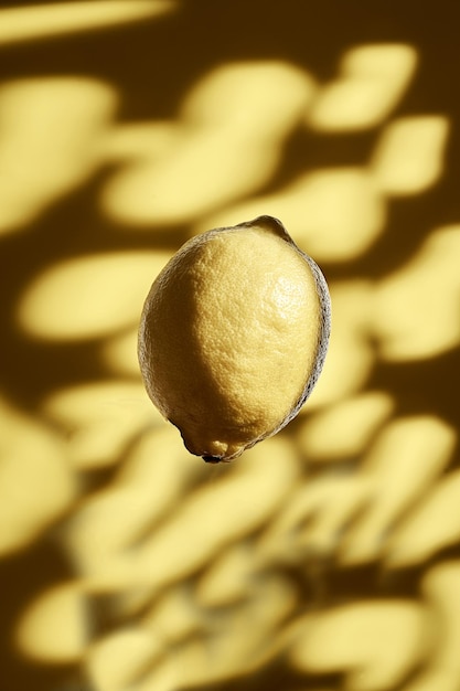 Eine schwebende Zitrone vor einem gefleckten Hintergrund. Frisches Obst-Konzept. Alles ist gelb