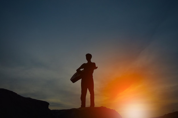 Eine Silhouette eines Mannes, der eine Gitarre hält und sich an den Händen hält