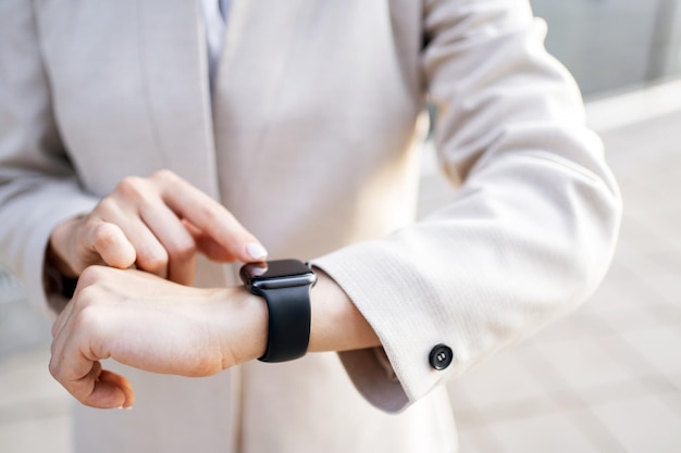 Eine Smartwatch an der Hand einer Frau berührt das Display mit ihrem Finger