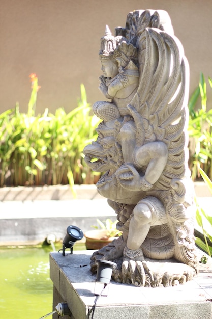 Eine Statue eines Drachen mit einem Wasserbrunnen im Hintergrund.