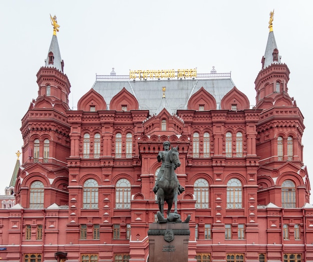 Eine Statue eines Pferdes steht vor einem Gebäude mit dem Wort Moskau darauf.