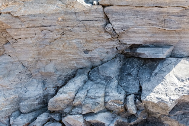 Eine steile Klippe aus grobem Sandstein Das Muster und die Textur von Naturstein Als Steinhintergrund