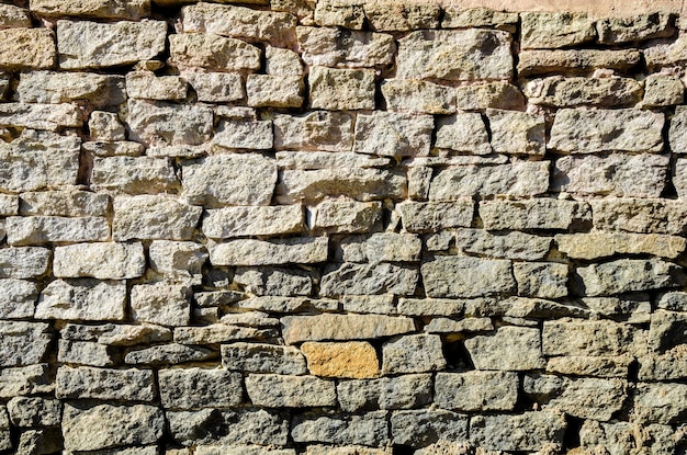 Eine Steinmauer mit einem gelben Stein in der Mitte.