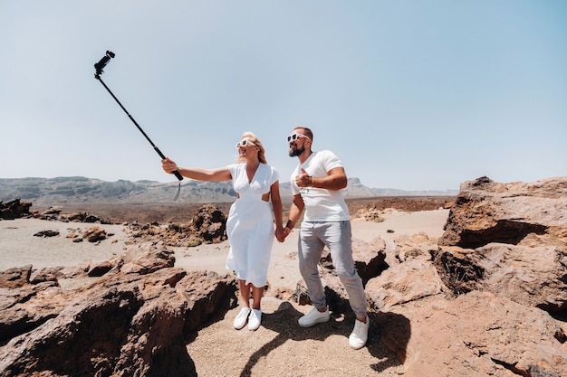 Eine stilvolle Frau macht ein Selfie im Krater des Teide-Vulkans. Wüstenlandschaft auf Teneriffa. Teide-Nationalpark. Wüstenkrater des Teide-Vulkans. Teneriffa, Kanarische Inseln.