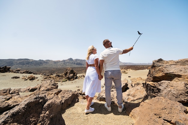 Eine stilvolle Frau macht ein Selfie im Krater des Teide-Vulkans. Wüstenlandschaft auf Teneriffa.