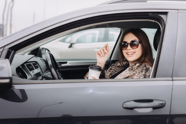 Eine stilvolle junge Frau sucht ein neues Auto in einem Autohaus