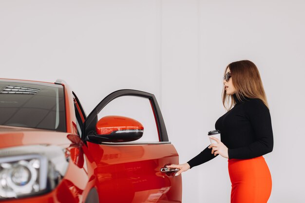 Eine stilvolle junge Frau sucht ein neues Auto in einem Autohaus