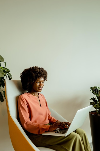 Foto eine strahlende afroamerikanische unternehmerin, die an einem friedlichen morgen in ihrem modernen arbeitsraum innovationen anstrebt