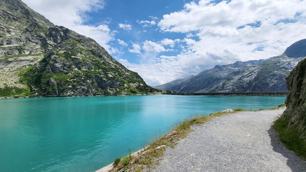 Foto eine straße, die zum gelmersee mit bergen im hintergrund im schweizer berner oberland führt