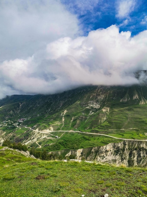 Eine Straße in den Bergen von Dagestan mit großen Bergen im Hintergrund und Wolken Russland