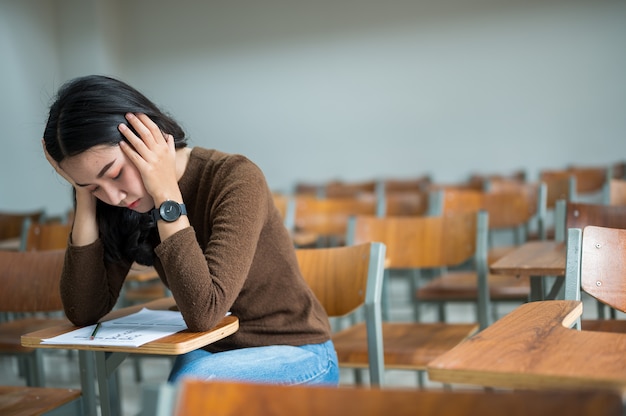 Eine Studentin, die in einem stressigen Klassenzimmer sitzt