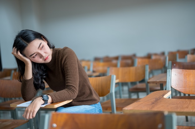 Eine Studentin, die in einem stressigen Klassenzimmer sitzt