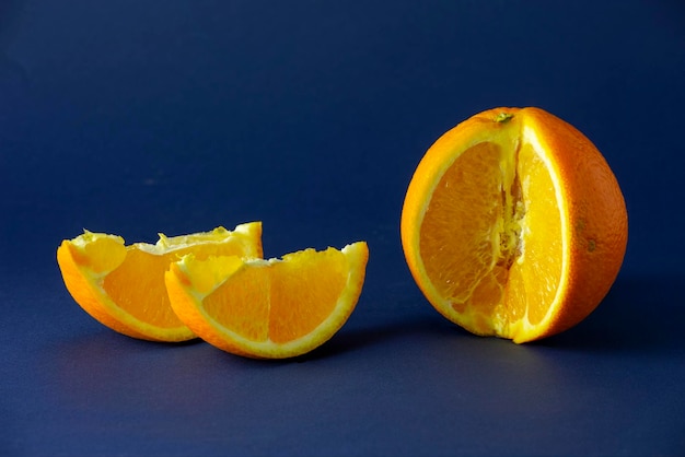 Eine süße Orange mit zwei Scheiben daneben ist ein Thema Fotografie Stilllebenfoto mit Orangenfrüchten