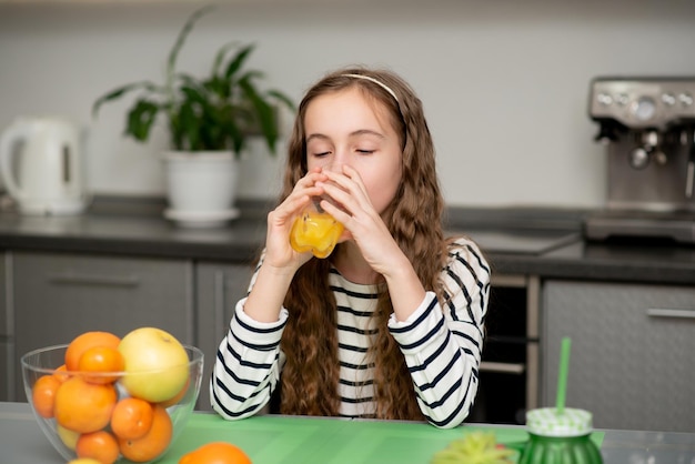 Eine süße Teenager-Mädchen trinken eine frische Orange Gesunde Ernährung Familie Frisches Obst