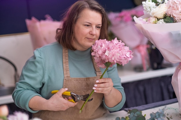 Eine talentierte Floristin kreiert einen wunderschönen Strauß-Blumenladen